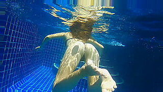 Three sultry ebony dolls dive into a pool, splashing and playing.