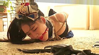 Una dolce ragazza asiatica sopporta un intenso bondage e BDSM in un video JAV.