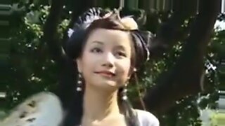 Seorang kecantikan Cina yang cantik berjalan-jalan melalui taman zaman dulu.